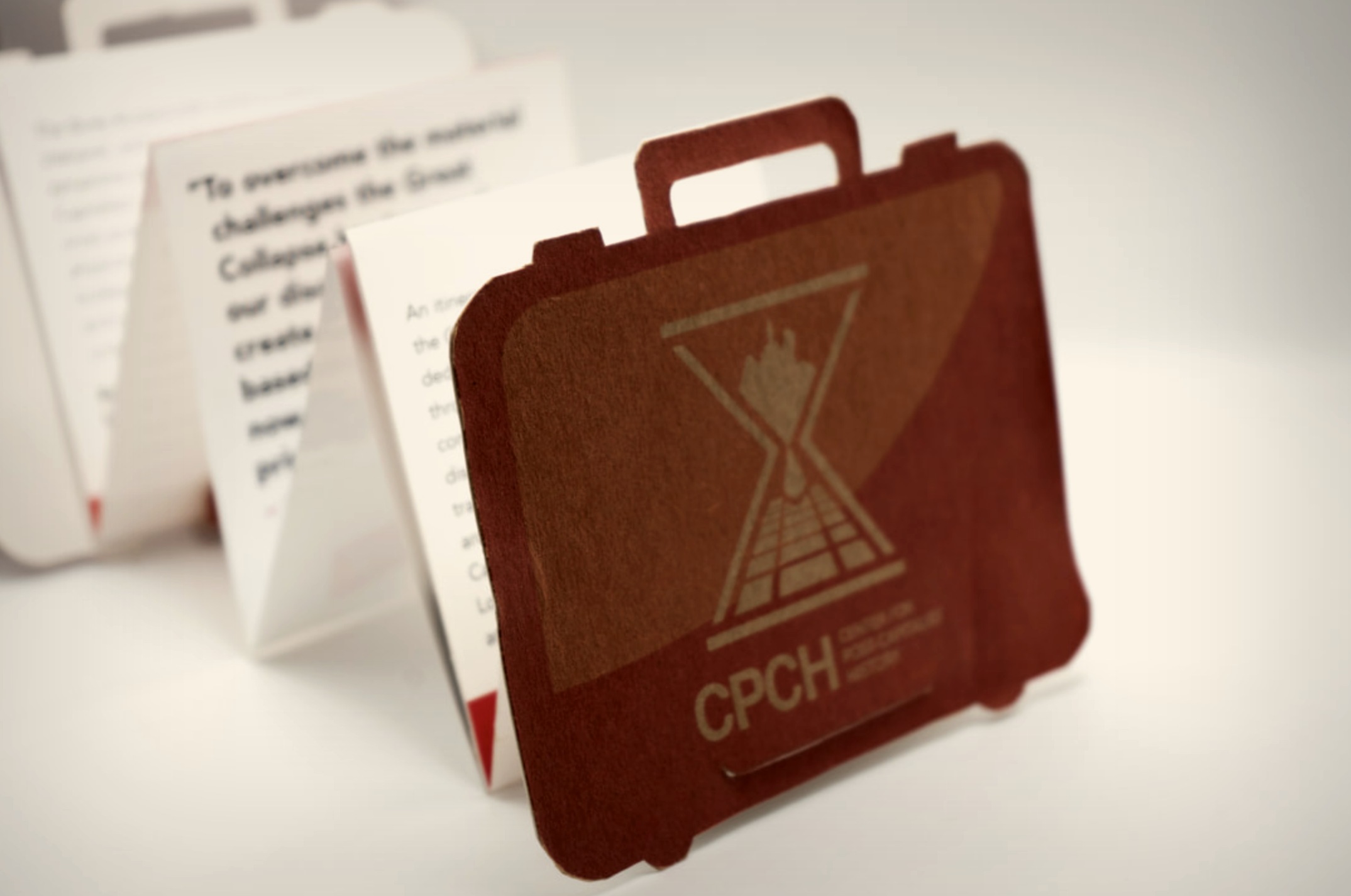 CPCH die-cut briefcase brochure — dark close-up with accordion pages