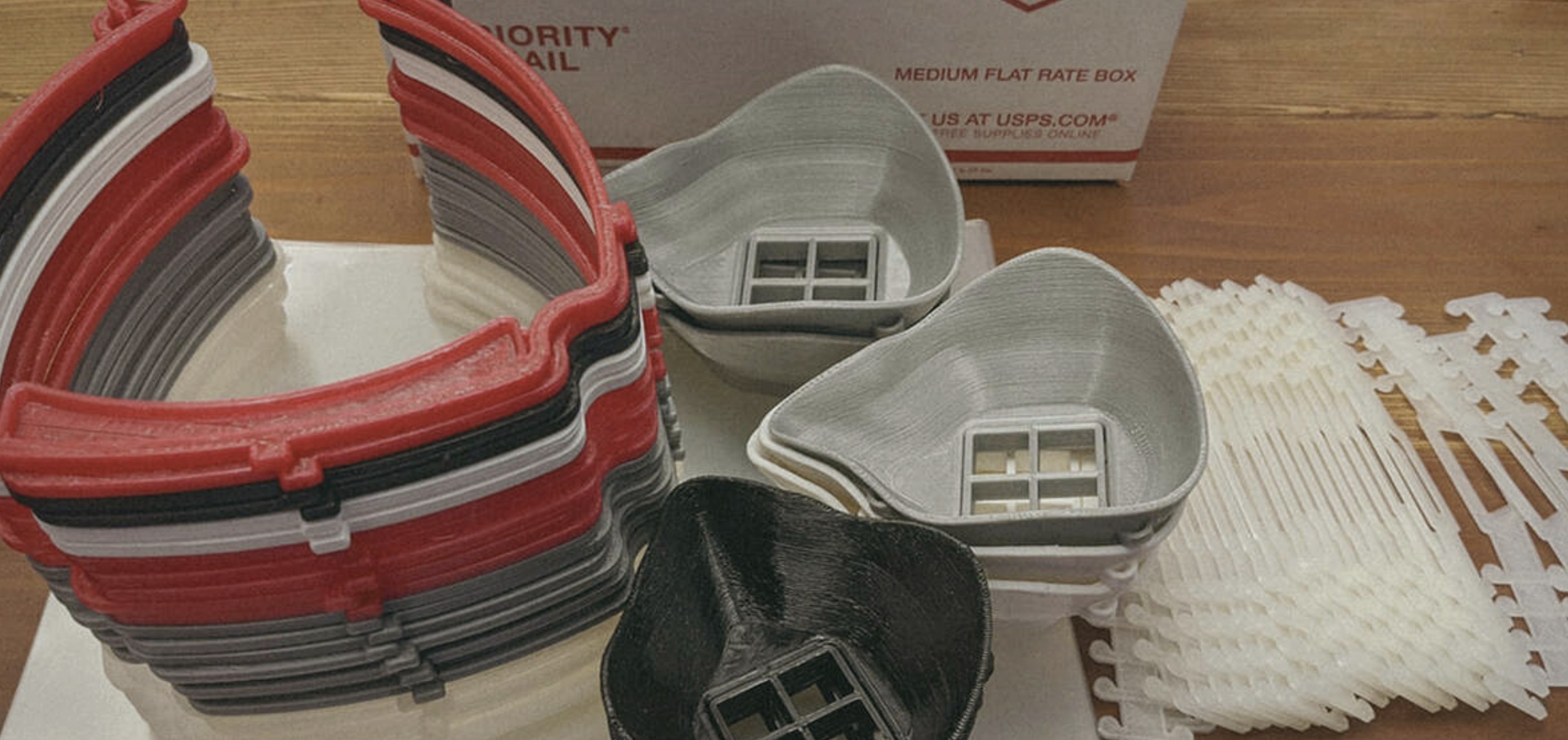 3D-printed PPE components — face shield frames and filter adapters in multiple colors